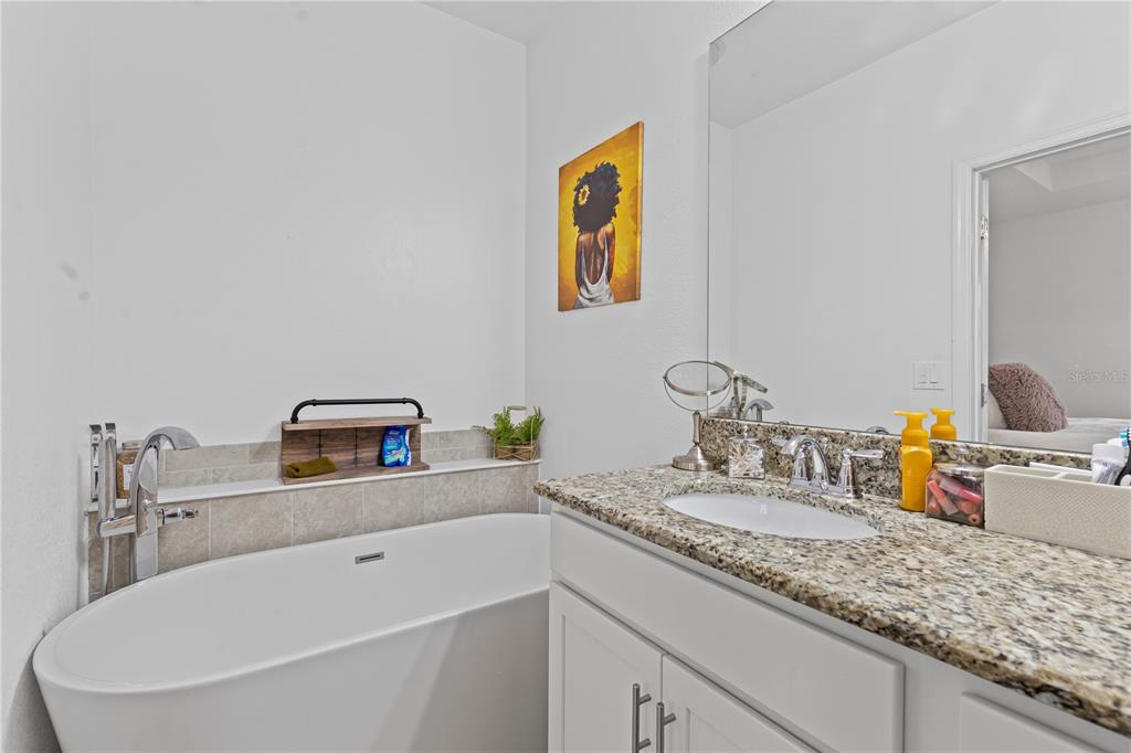 5119 Jones Road St. Cloud, FL 34771 - Photo 16 of 41 a bathroom with a granite countertop sink and a mirror