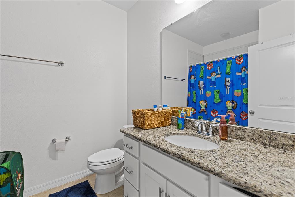 5119 Jones Road St. Cloud, FL 34771 - Photo 25 of 41 a bathroom with a granite countertop sink and a mirror
