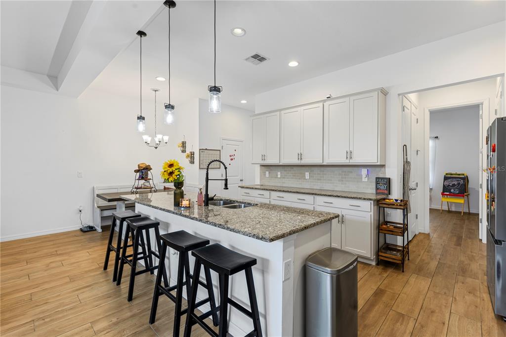 5119 Jones Road St. Cloud, FL 34771 - Photo 5 of 41 a kitchen with stainless steel appliances granite countertop a table chairs stove and wooden floor