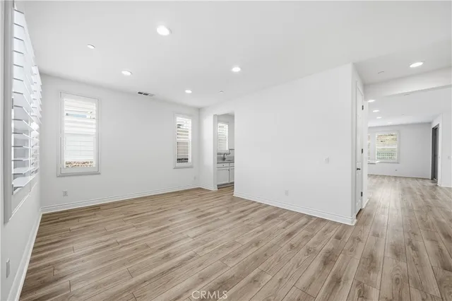 a view of empty room with wooden floor and fireplace
