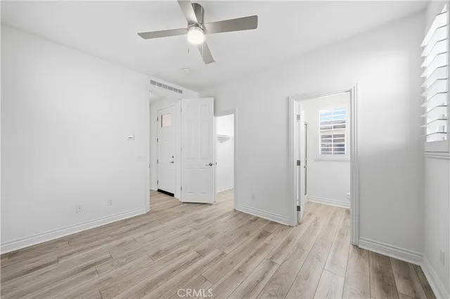 a view of a big room with wooden floor and windows