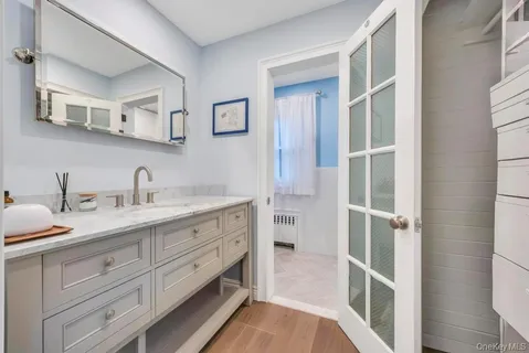 a spacious bathroom with a double vanity sink a mirror and a shower