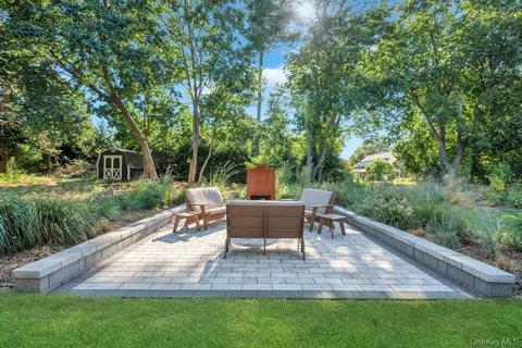 a view of a patio with table and chairs potted plants with large tree