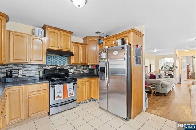 a kitchen with stainless steel appliances granite countertop a refrigerator and a stove