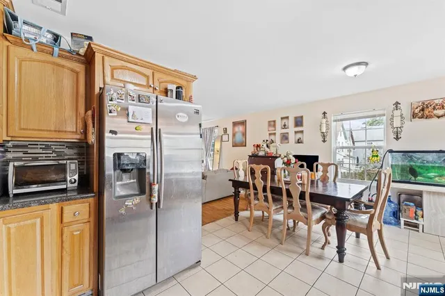 a dining area with stainless steel appliances a refrigerator and a stove top oven