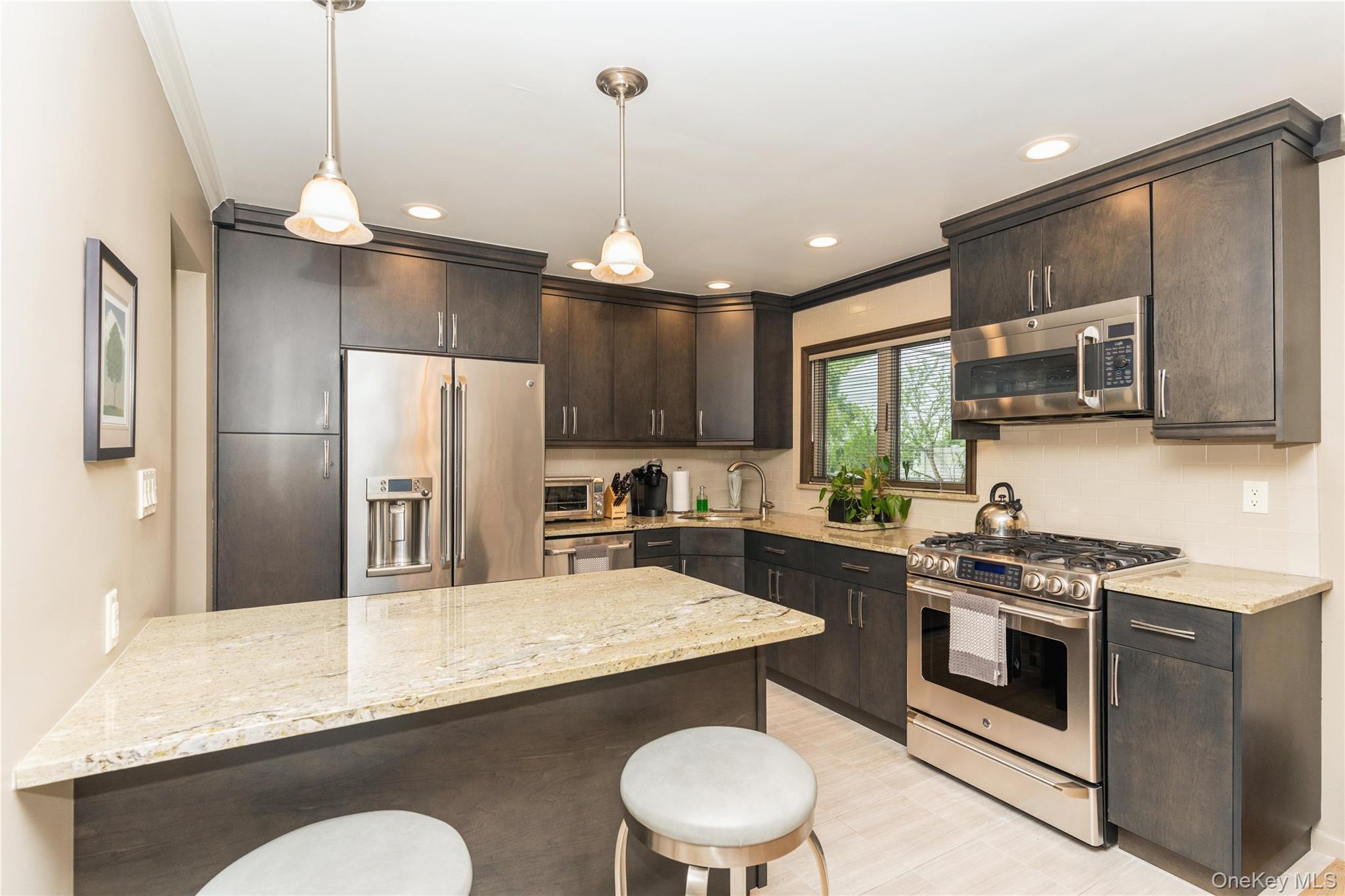 2772 Riverside Avenue Merrick, NY 11566 - Photo 3 of 45 a kitchen with stainless steel appliances granite countertop a sink a stove a refrigerator cabinets and chairs