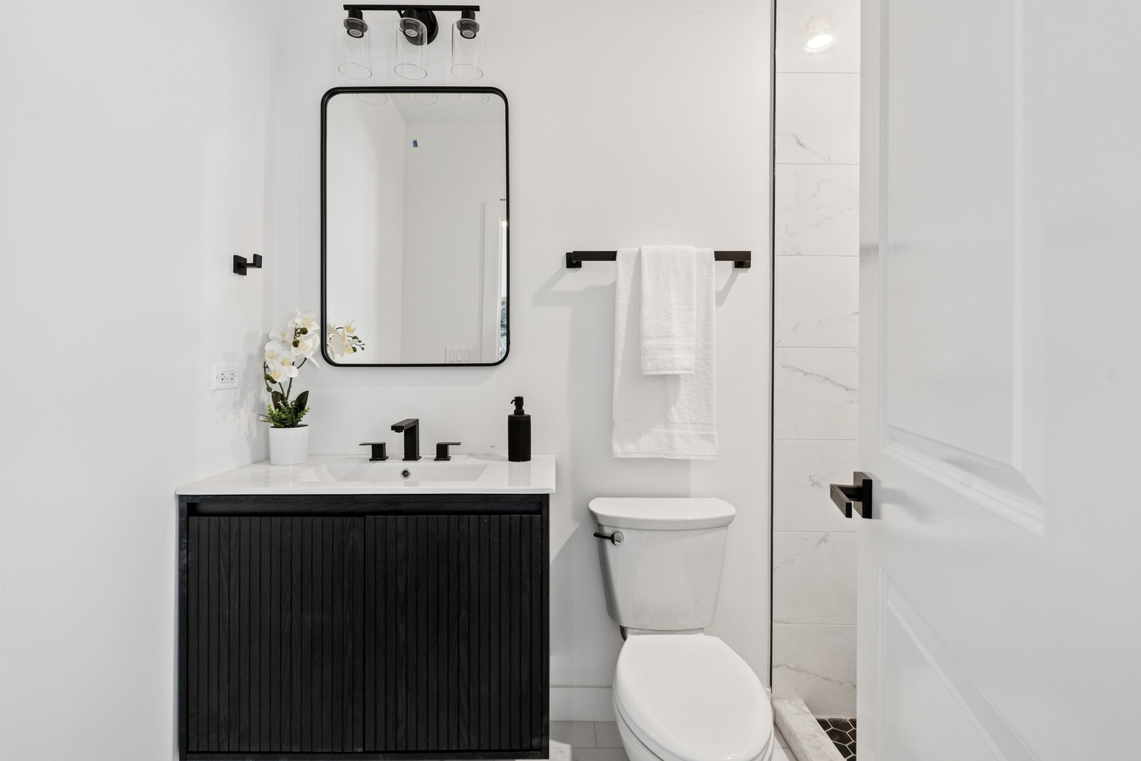 6755 North Hermitage Avenue, Unit 1 Chicago, IL 60626 - Photo 11 of 16 a bathroom with a toilet sink vanity and mirror