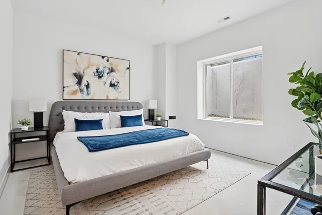 a bedroom with a bed and a painting on the wall