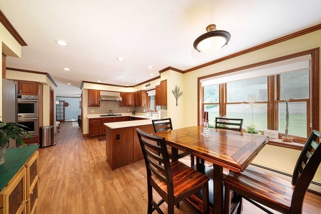 47 Southboro Road Upton, MA 01568 - Photo 11 of 42 a kitchen with stainless steel appliances granite countertop a stove top oven a sink dishwasher a dining table and chairs with wooden floor