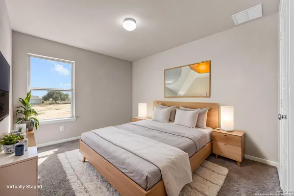 a bedroom with a bed and a painting on the wall