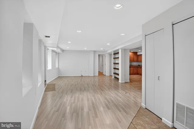 a view of empty room with wooden floor