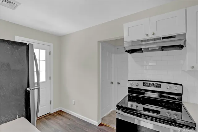 a view of kitchen with wooden floor and electronic appliances
