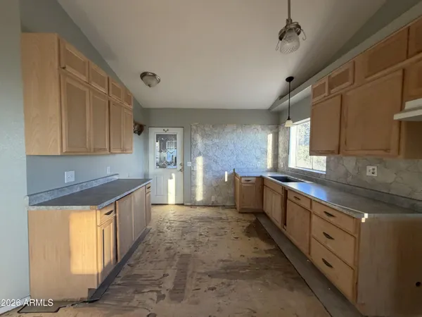 a large kitchen with stainless steel appliances granite countertop a sink and cabinets