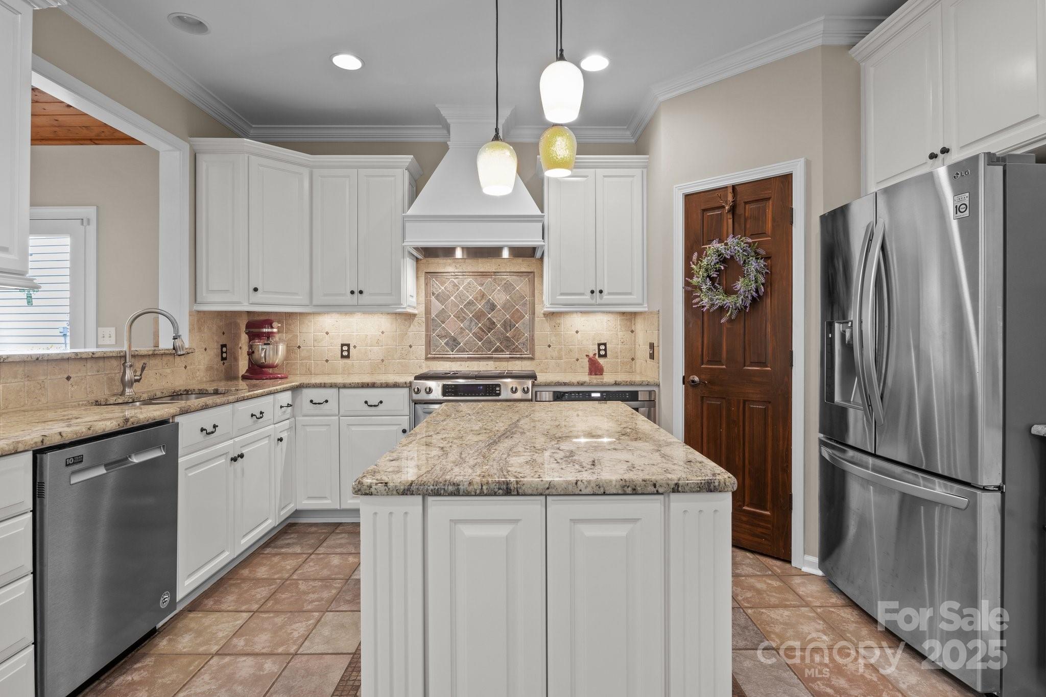 7710 Epping Forest Drive Huntersville, NC 28078 - Photo 8 of 37 a kitchen with kitchen island granite countertop a refrigerator a sink and white cabinets