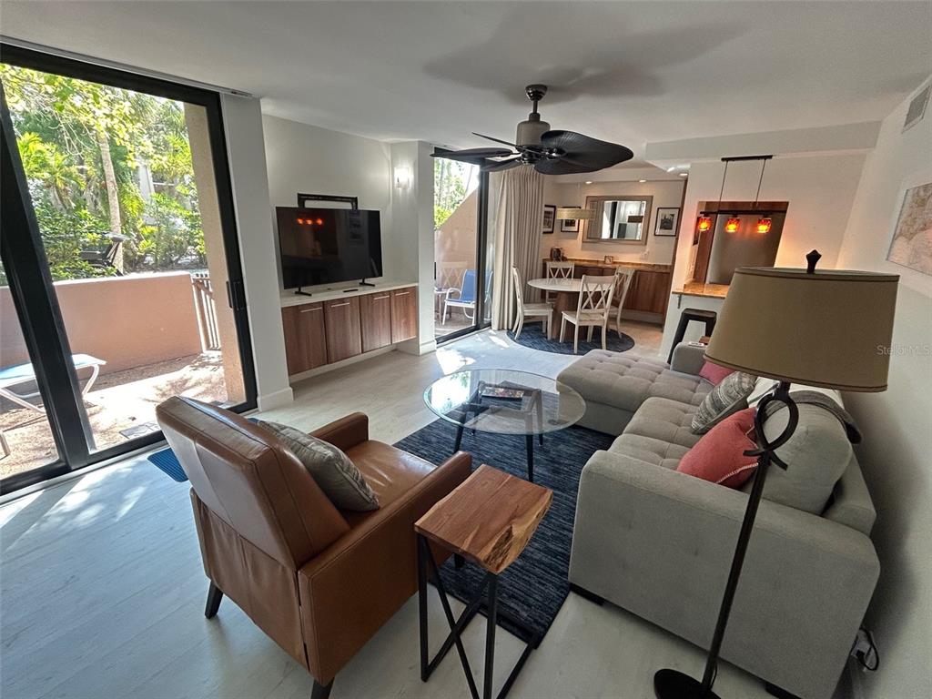 111 Pass Key Road, Unit 111 Sarasota, FL 34242 - Photo 6 of 23 a living room with furniture a flat screen tv and a large window