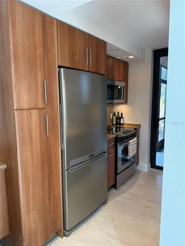a kitchen with stainless steel appliances a refrigerator and a stove top oven