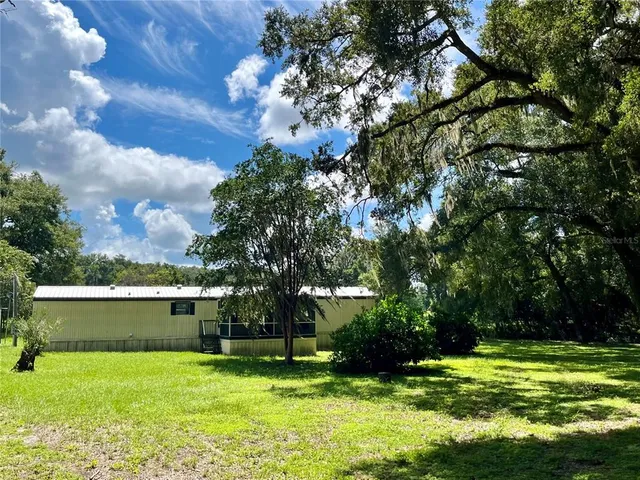 a view of a backyard with large trees