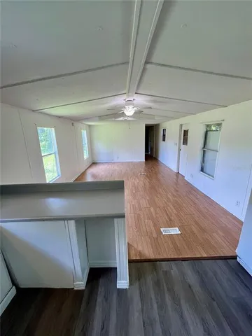 a room with a wooden floor and chandelier