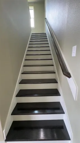 an empty room with wooden floor chandelier fan and windows