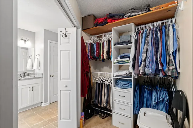 a view of walk in closet with clothes and shoes
