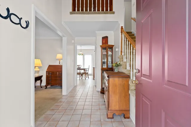 a view of a hallway with dining area and chandelier