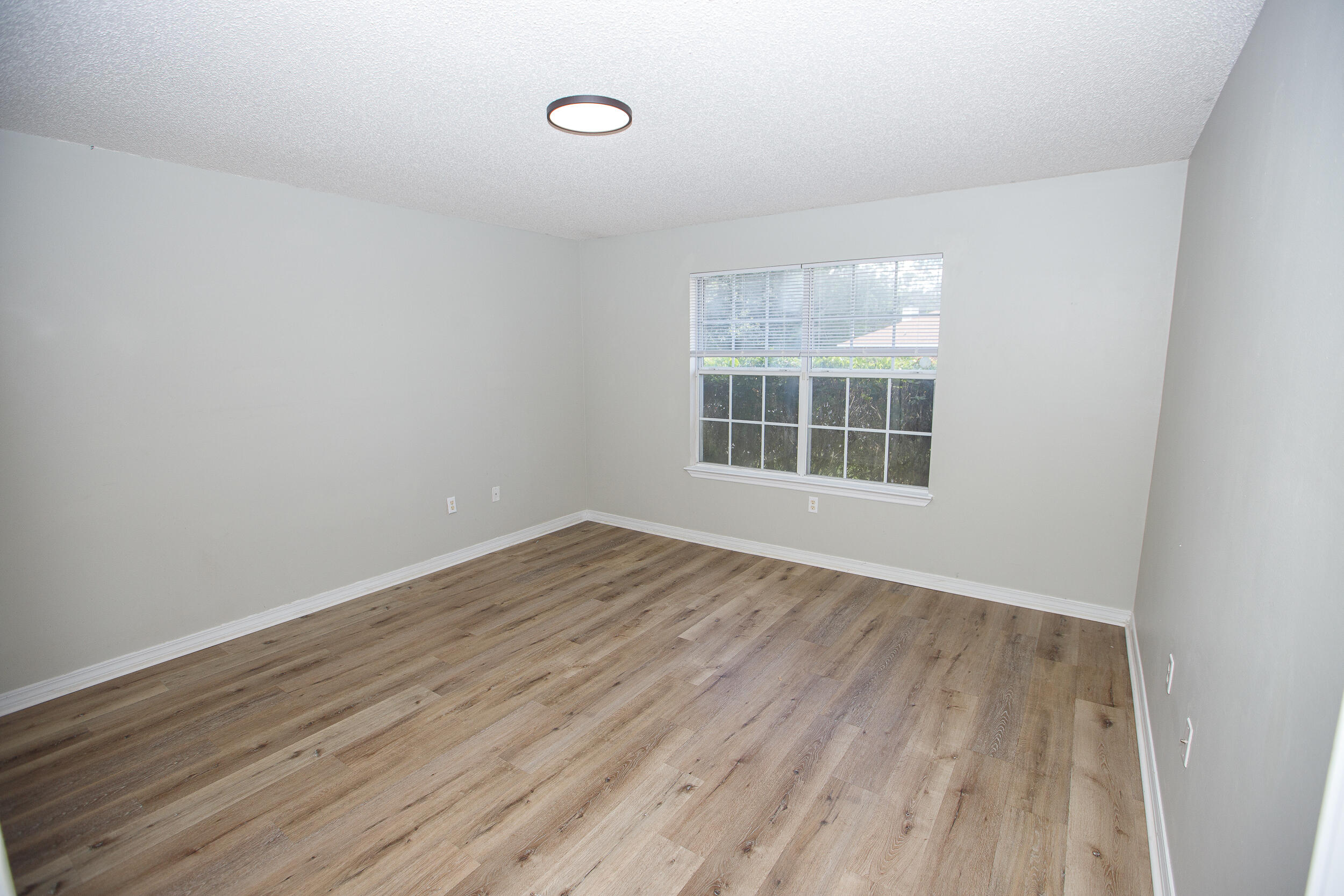 1305 Jefferyscot Court Crestview, FL 32536 - Photo 13 of 20 an empty room with wooden floor and windows