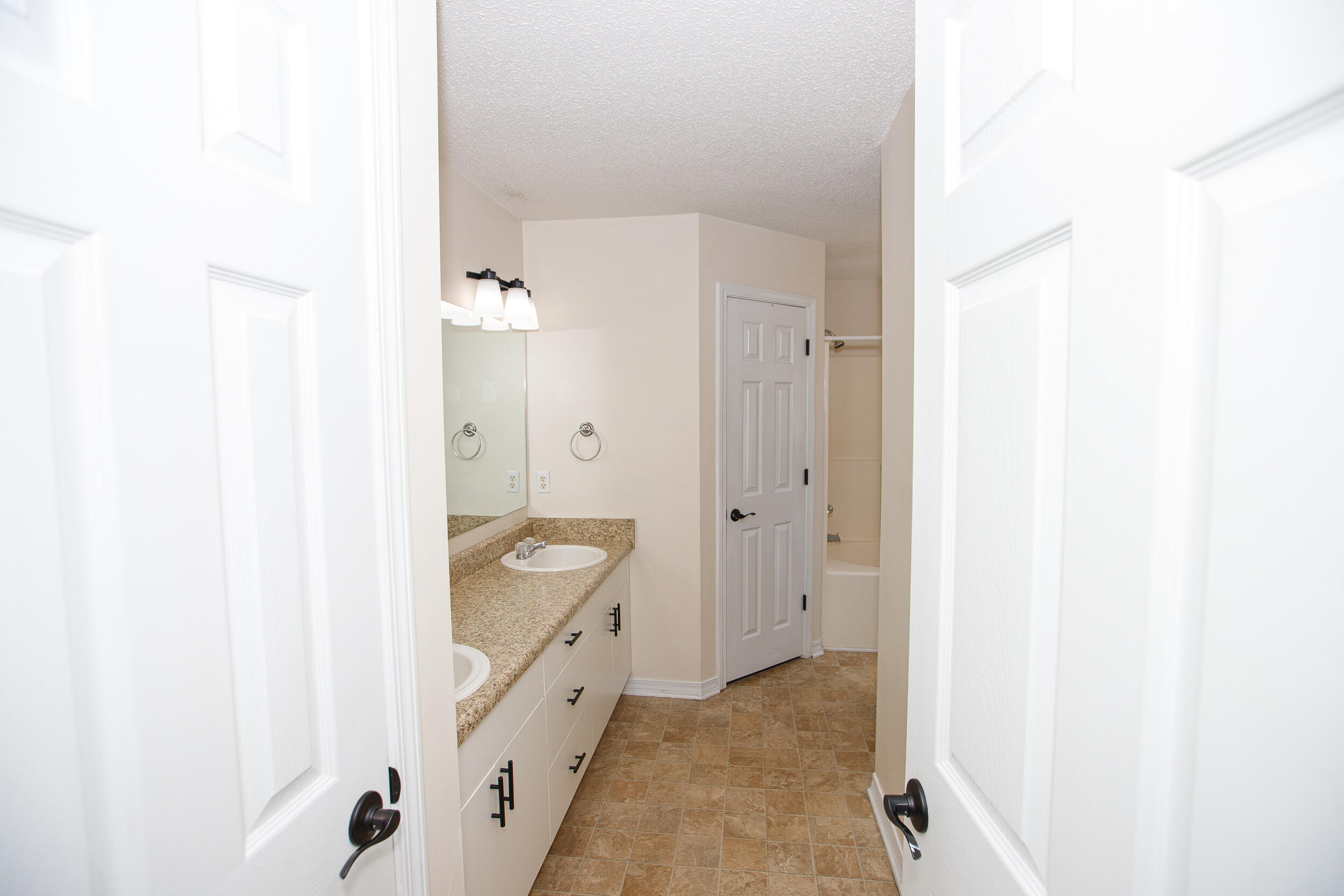 1305 Jefferyscot Court Crestview, FL 32536 - Photo 14 of 20 a bathroom with a granite countertop sink a mirror and a bathtub