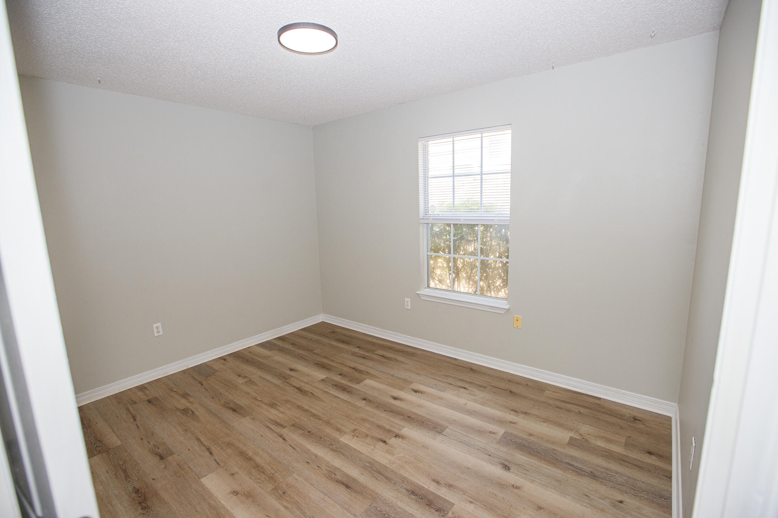 1305 Jefferyscot Court Crestview, FL 32536 - Photo 9 of 20 an empty room with wooden floor and windows