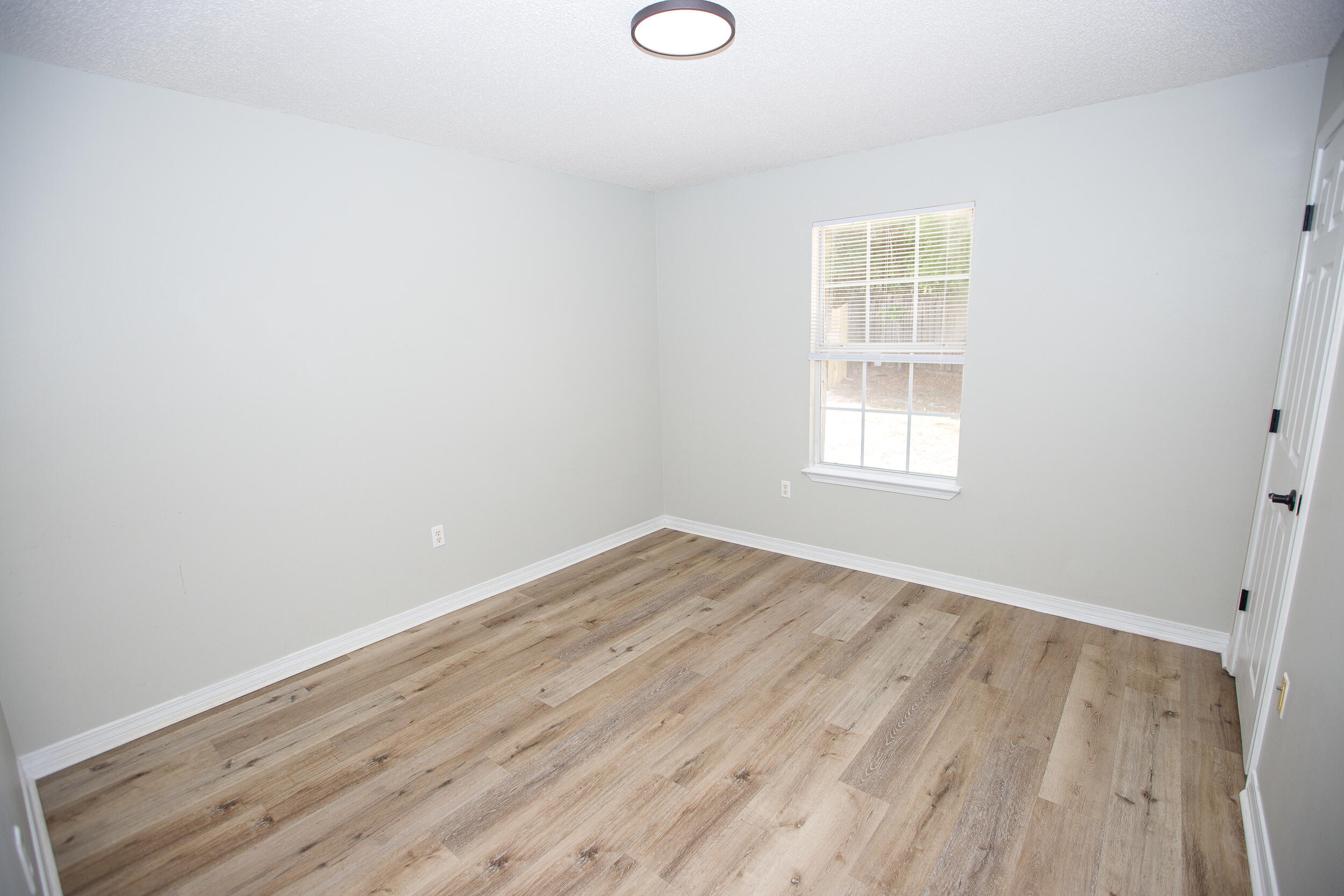 1305 Jefferyscot Court Crestview, FL 32536 - Photo 10 of 20 an empty room with wooden floor and windows