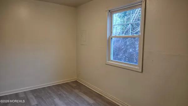 a view of a small space with wooden floor and a window