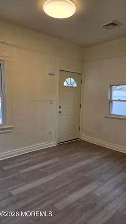 a view of a small space with wooden floor and a window