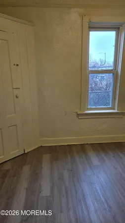 a view of a small space with wooden floor and a window