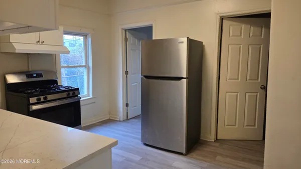 a kitchen with a refrigerator and a stove top oven
