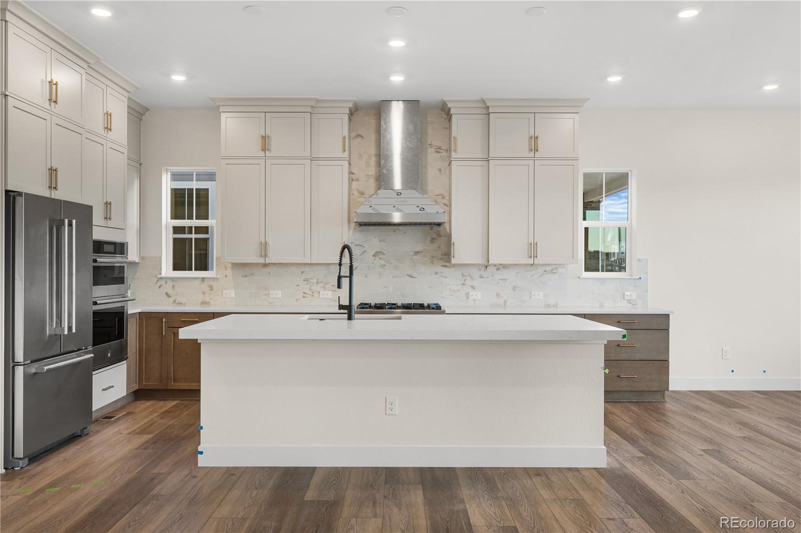 6749 Fawn Path Lane Castle Pines, CO 80108 - Photo 11 of 33 a kitchen with kitchen island granite countertop a sink and a refrigerator