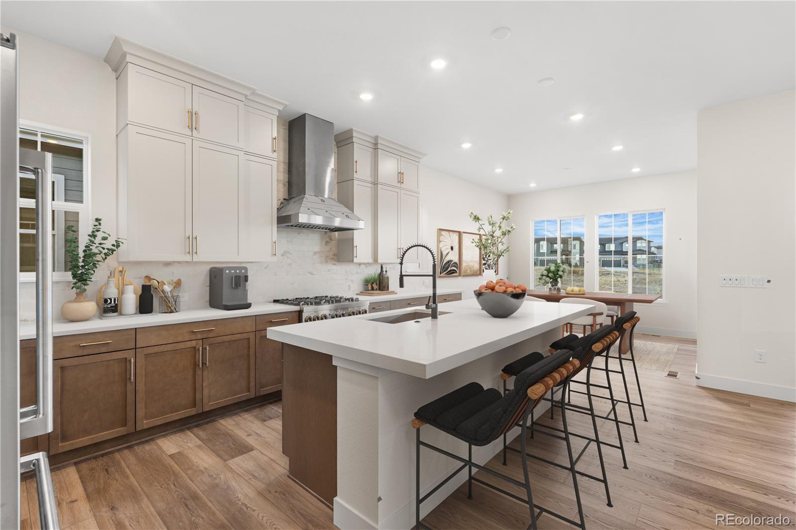 6749 Fawn Path Lane Castle Pines, CO 80108 - Photo 15 of 33 a kitchen with stainless steel appliances granite countertop a stove a sink a refrigerator and white cabinets with wooden floor