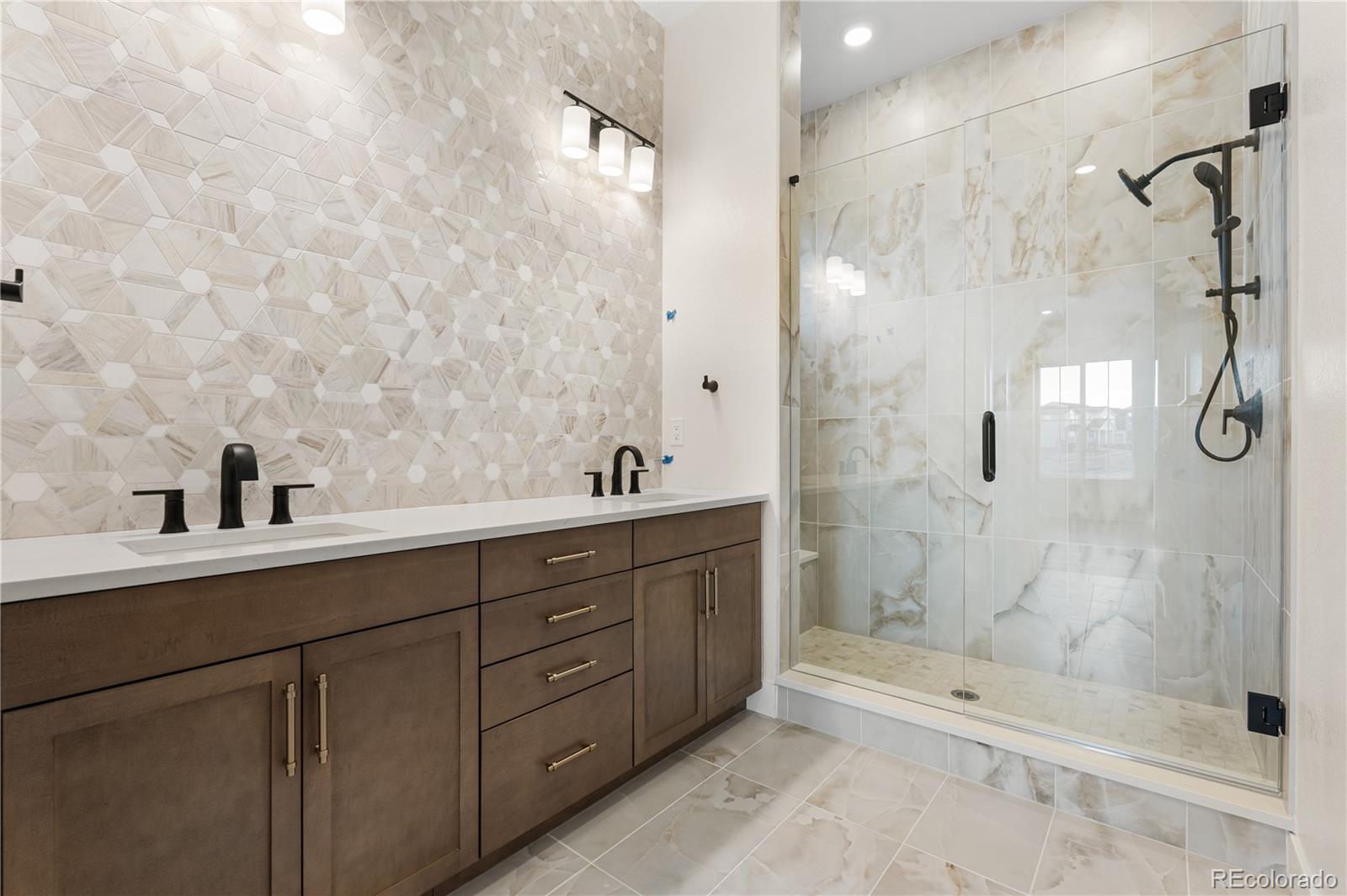 6749 Fawn Path Lane Castle Pines, CO 80108 - Photo 21 of 33 a bathroom with a double vanity sink toilet and shower