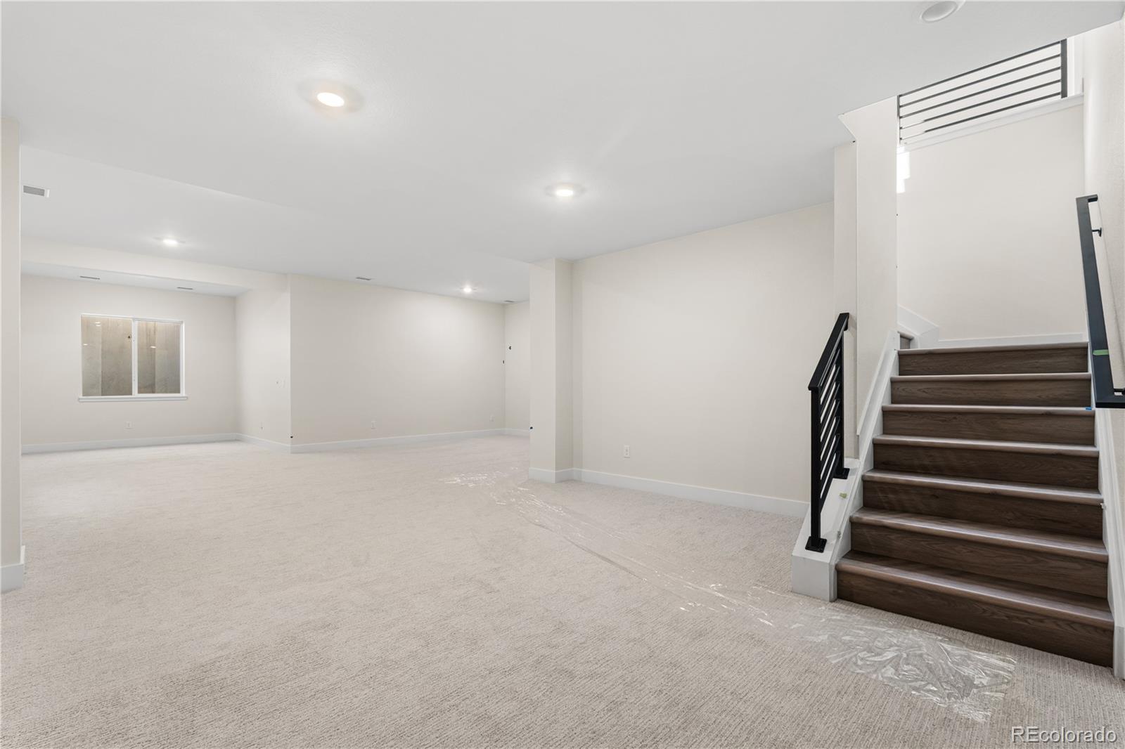 6749 Fawn Path Lane Castle Pines, CO 80108 - Photo 29 of 33 en empty room with stairs and wooden floor