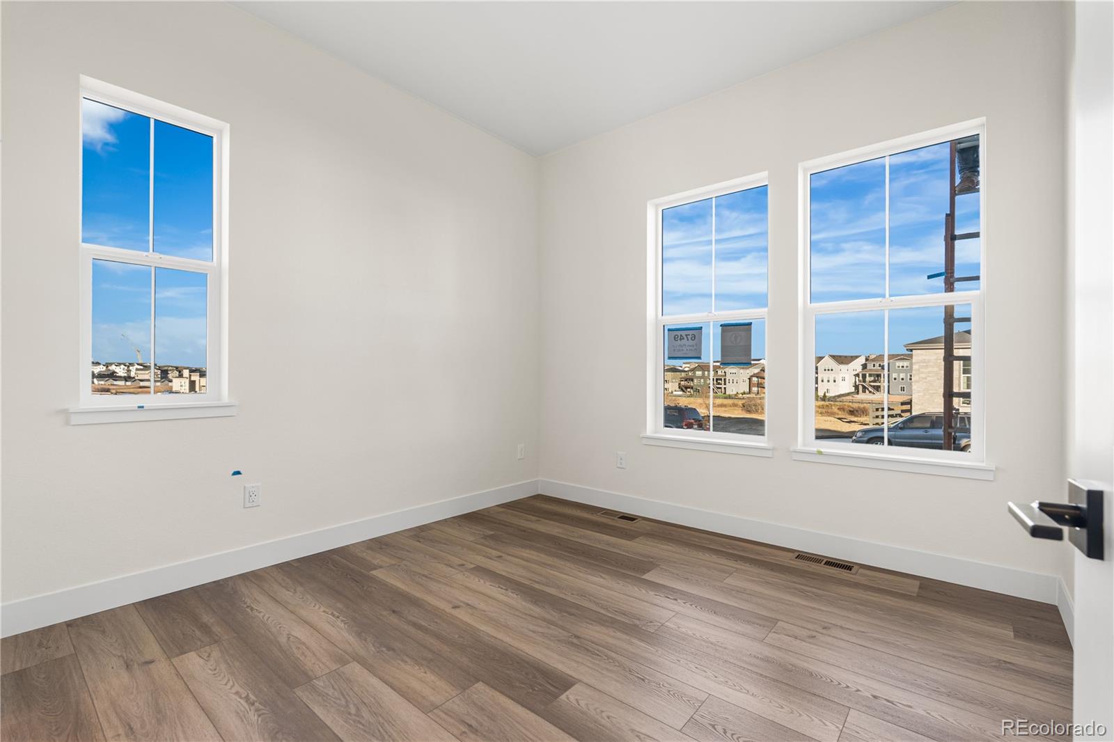 6749 Fawn Path Lane Castle Pines, CO 80108 - Photo 8 of 33 a view of an empty room with wooden floor and a window