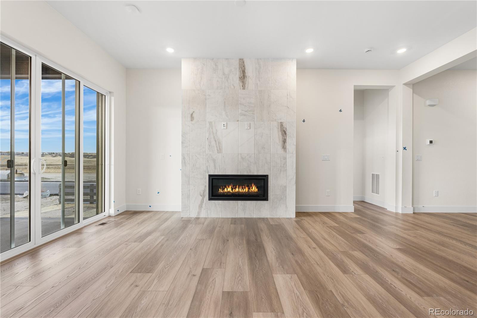 6749 Fawn Path Lane Castle Pines, CO 80108 - Photo 9 of 33 a view of an empty room with wooden floor and a window