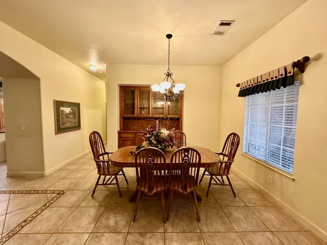 a view of a dining room and livingroom with furniture wooden floor a chandelier