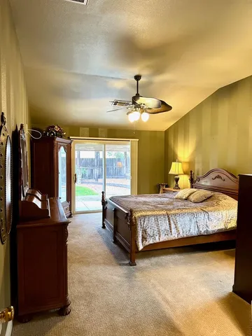 a spacious bedroom with a bed and ceiling fan