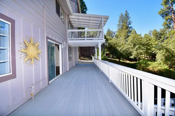 a view of a house with wooden deck and furniture