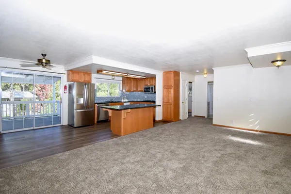 a kitchen with stainless steel appliances kitchen island granite countertop a refrigerator and stove