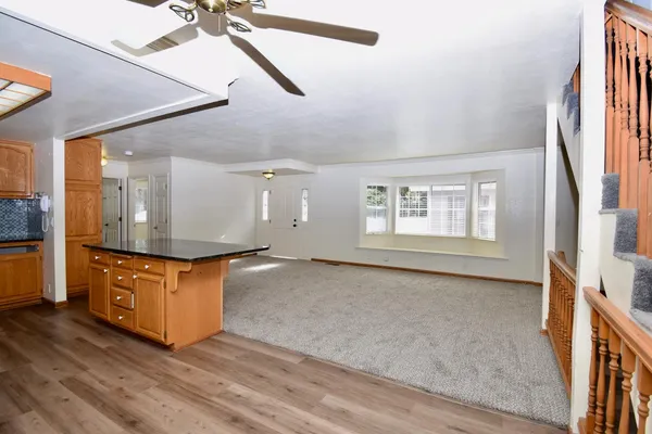a living room with stainless steel appliances granite countertop furniture and a wooden floor