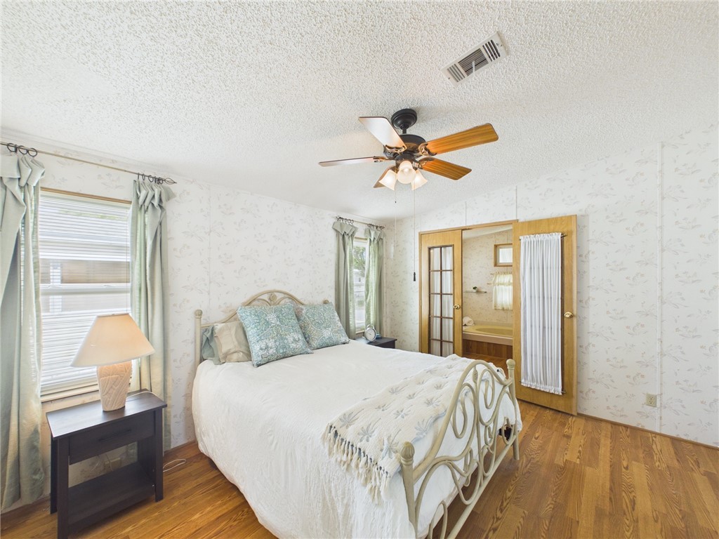 1203 Calusa Drive Sebastian, FL 32976 - Photo 15 of 27 a bedroom with a large bed and a chandelier