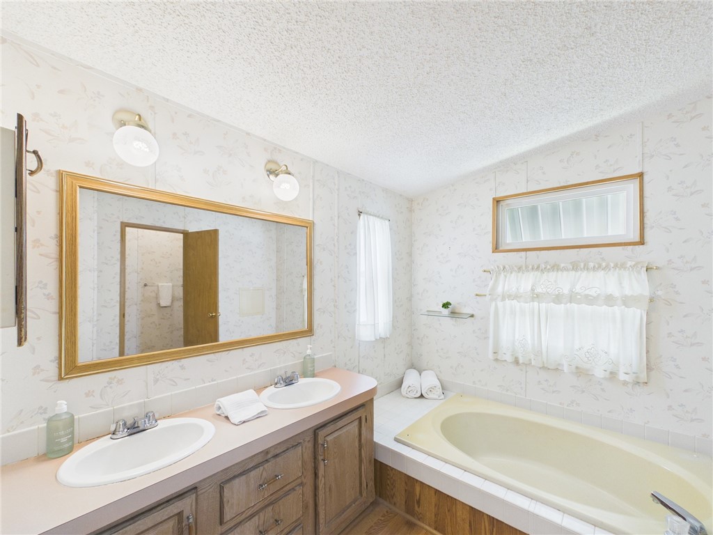 1203 Calusa Drive Sebastian, FL 32976 - Photo 17 of 27 a bathroom with a tub a sink and mirror