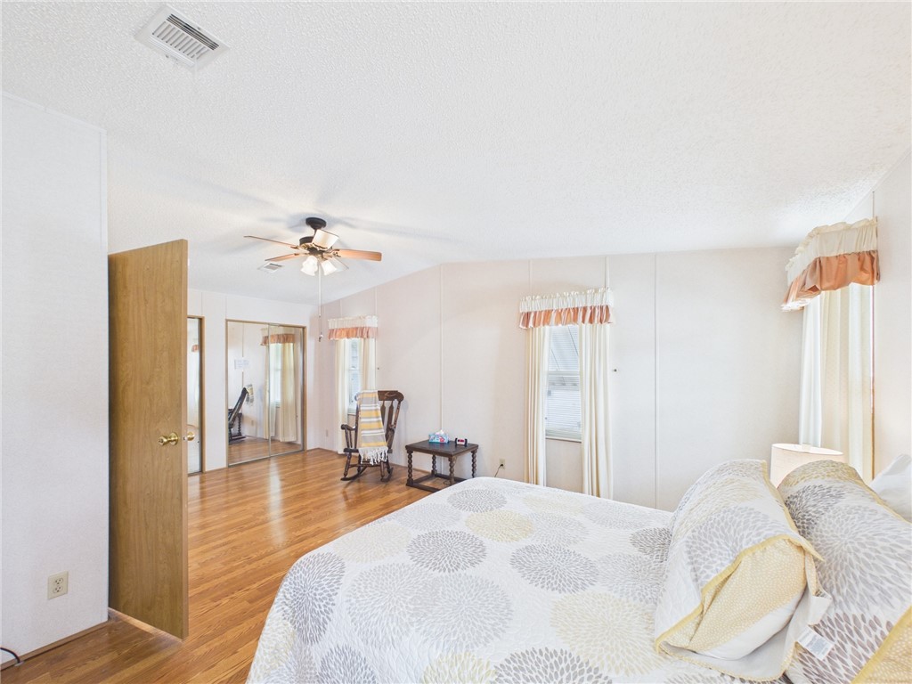1203 Calusa Drive Sebastian, FL 32976 - Photo 21 of 27 a bedroom with a bed and a chandelier