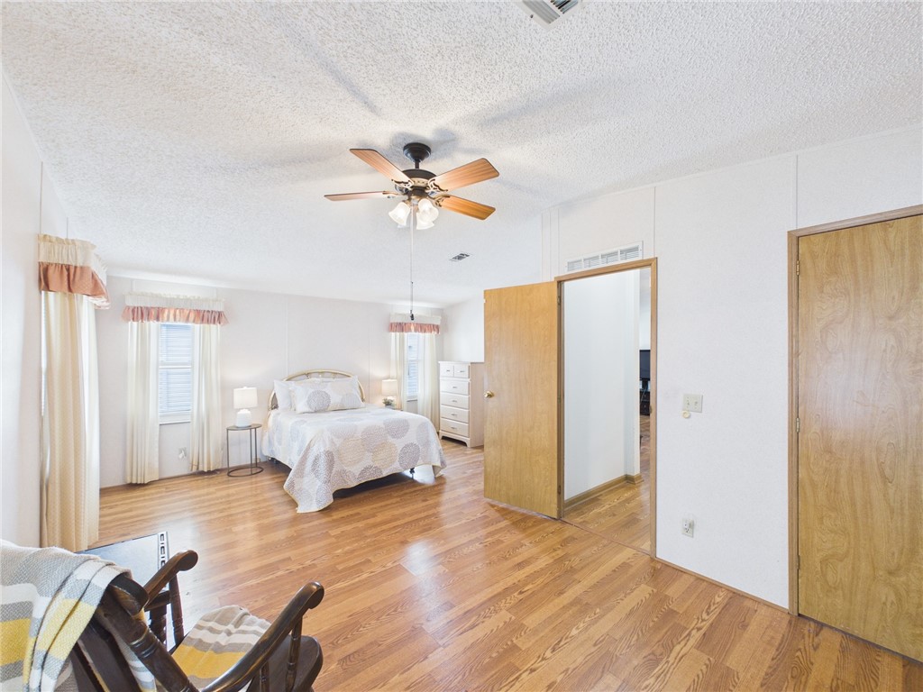 1203 Calusa Drive Sebastian, FL 32976 - Photo 22 of 27 a spacious bedroom with a bed and a chandelier