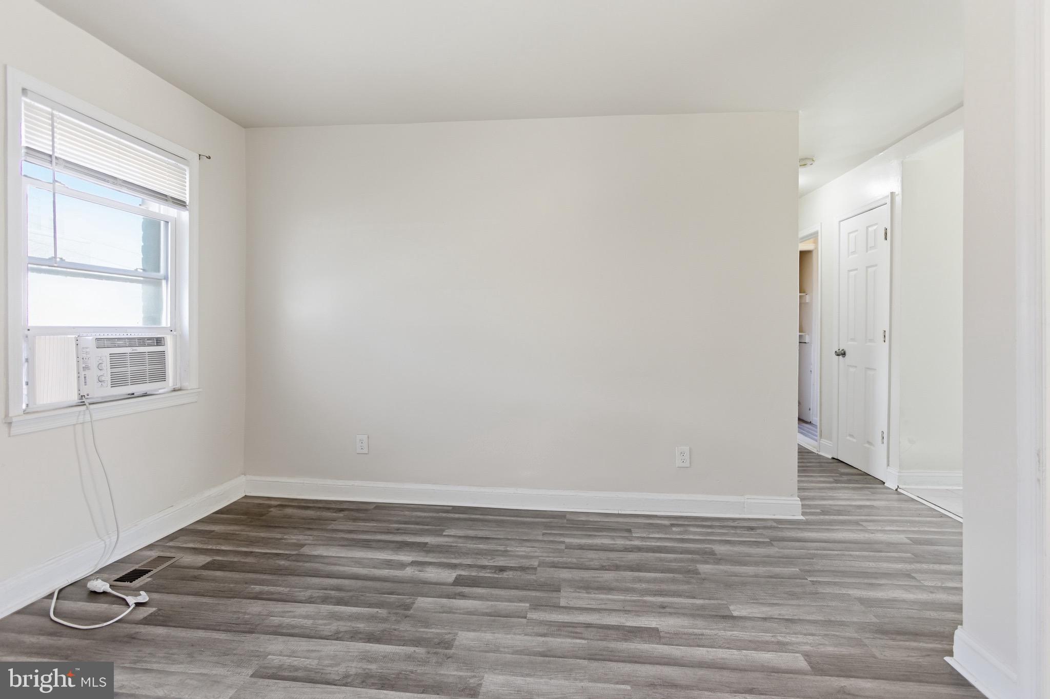 101 Wayne Place Southeast, Unit 2 Washington, DC 20032 - Photo 2 of 10 an empty room with wooden floor and windows