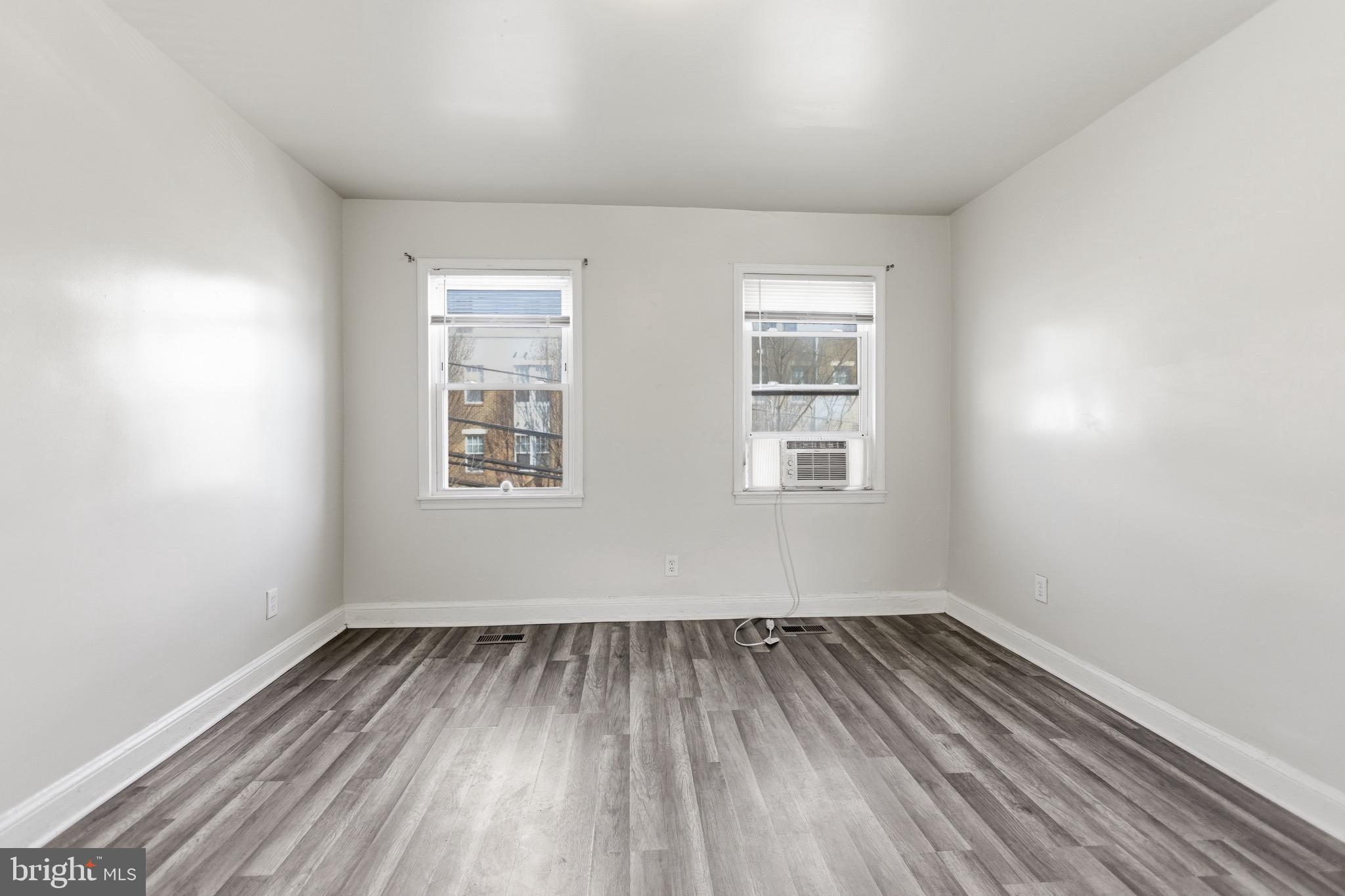 101 Wayne Place Southeast, Unit 2 Washington, DC 20032 - Photo 3 of 10 an empty room with wooden floor and windows